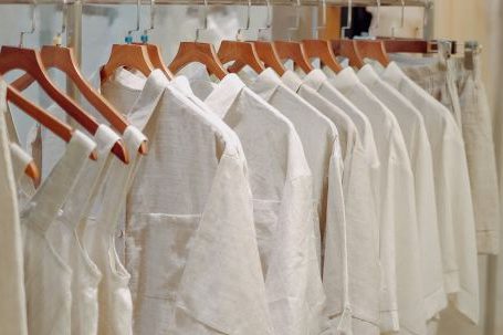 Capsule Wardrobe - Clothes in Neutral Colors Hanging on the Racks in a Clothing Store